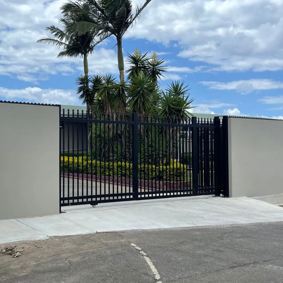 Modern gate with a white wall and black metal gate in a residential area.
