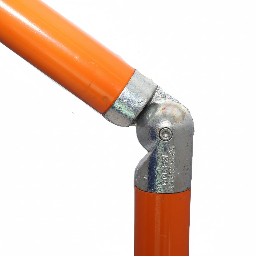 Close-up of a metal elbow fitting with orange pipe on a white background